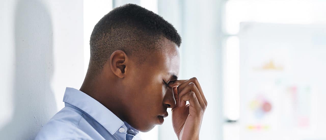 A person pinching the bridge of their nose