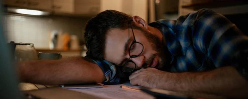 A person who's fallen asleep at their desk
