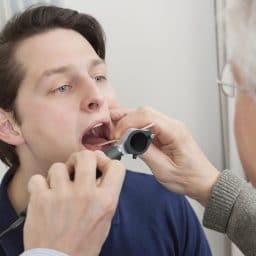 Man getting his throat examined by a doctor