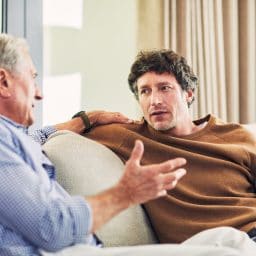 Shot of a mature man and his elderly father sitting on the sofa at home and chatting
