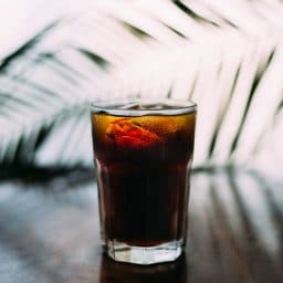 An iced dark beverage in a clear glass.