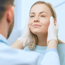 Woman getting examined by plastic surgeon.