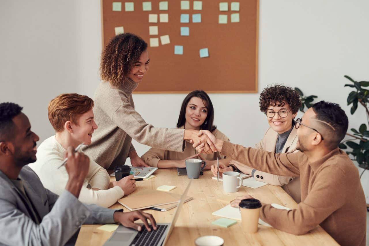 Coworkers shaking hands at a business meeting.