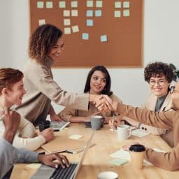 Coworkers shaking hands at a business meeting.