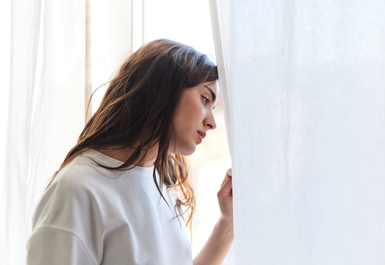 Depressed woman looking out the window. Woman with depression looking out the window.