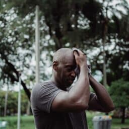Senior man wiping his brow after exercising in the summer heat.