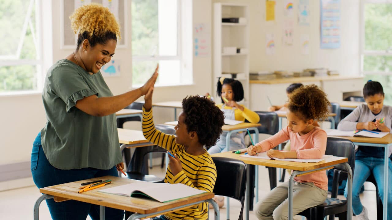 Teacher high-fiving a student during class.