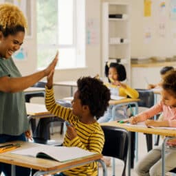 Teacher high-fiving a student during class