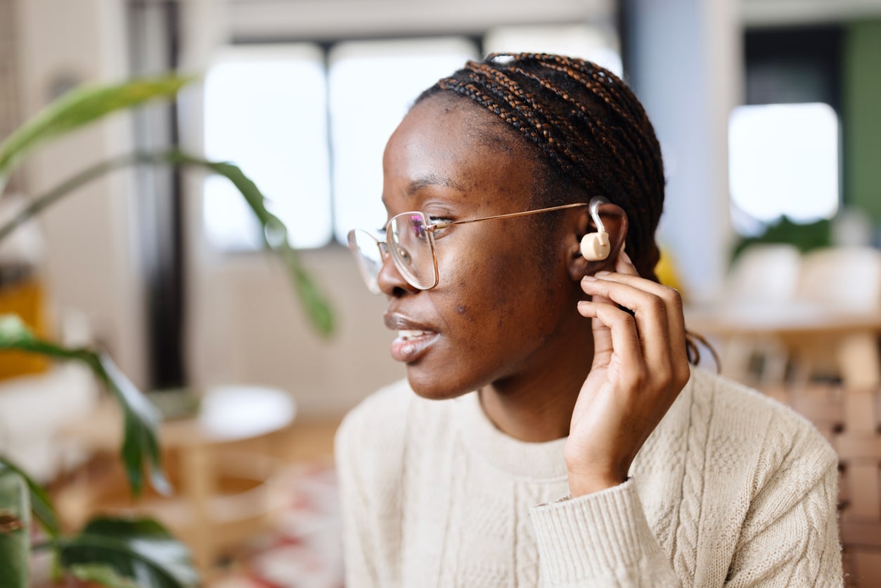 Young adult woman wearing a hearing aid.