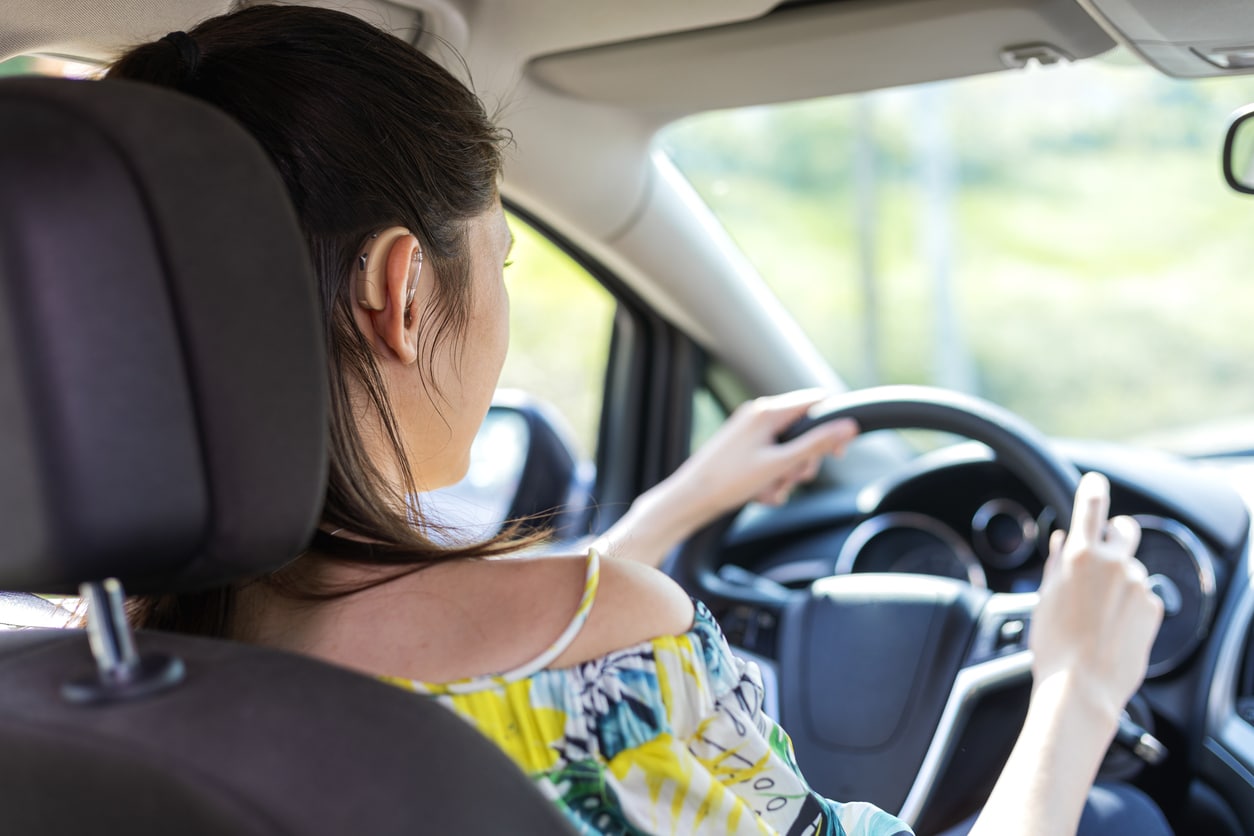 Woman with hearing aids drives car