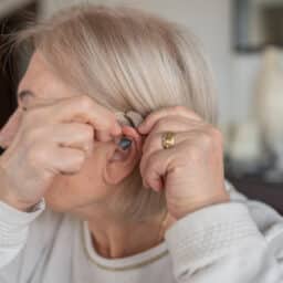 Senior woman trying on her new hearing aid
