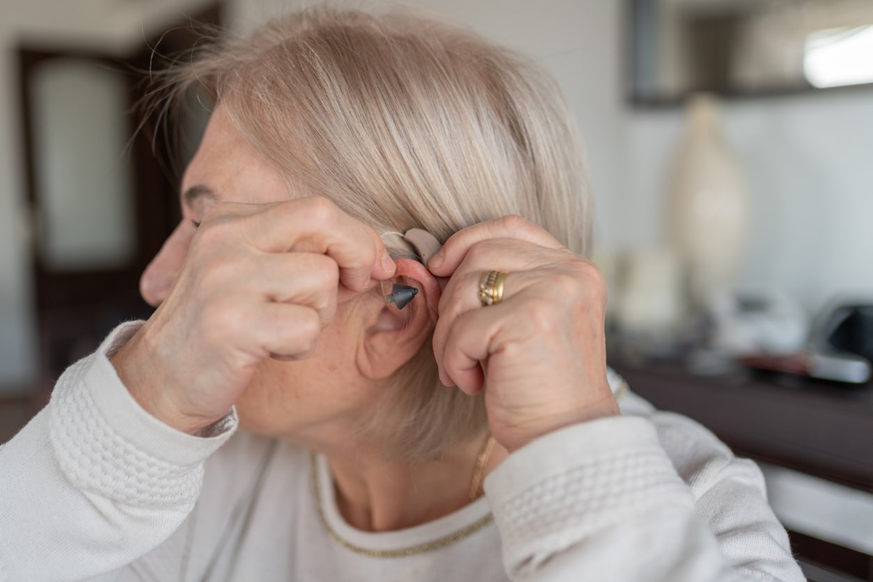 Senior woman trying on her new hearing aid.