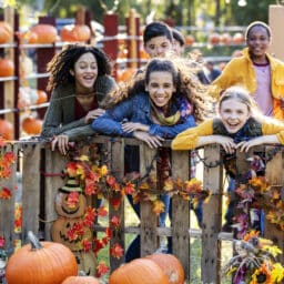 Group of kids laughing at a pumpkin patch
