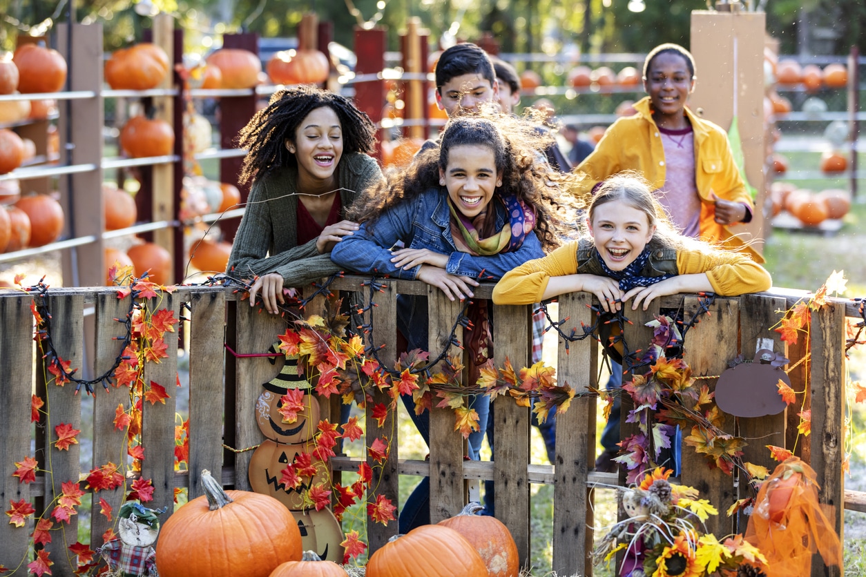 Group of kids laughing at a pumpkin patch