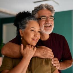 A couple standing together, looking happy.