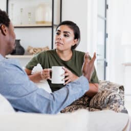 Couple talking on their couch.