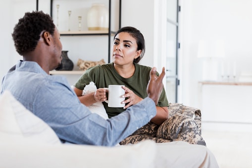 Couple talking on their couch.