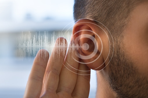 Man holding his hand up to his ear. Hearing loss concept.