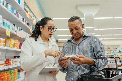 A pharmacist explaining a medication to a customer in the pharmacy.